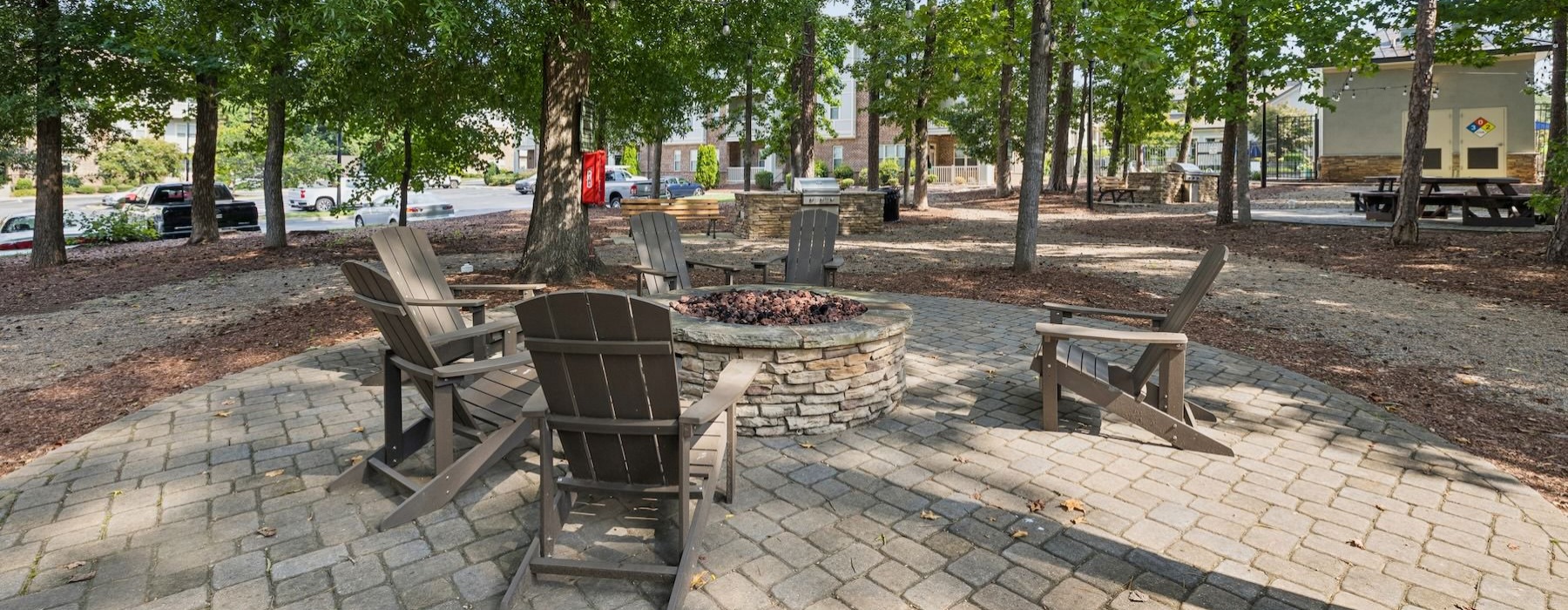 a courtyard with a fire pit and chairs