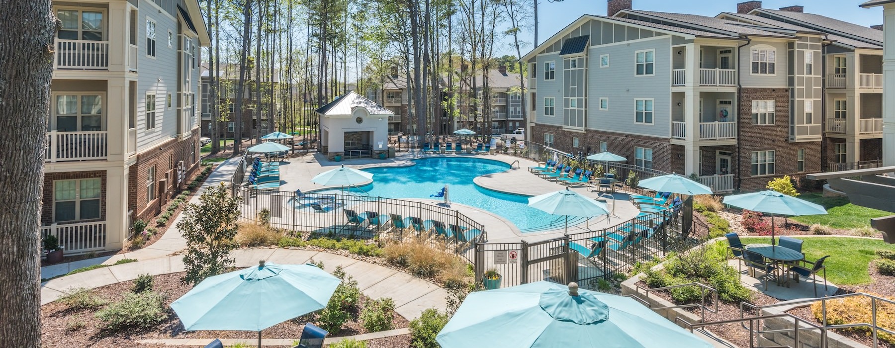 a courtyard with a pool and umbrellas