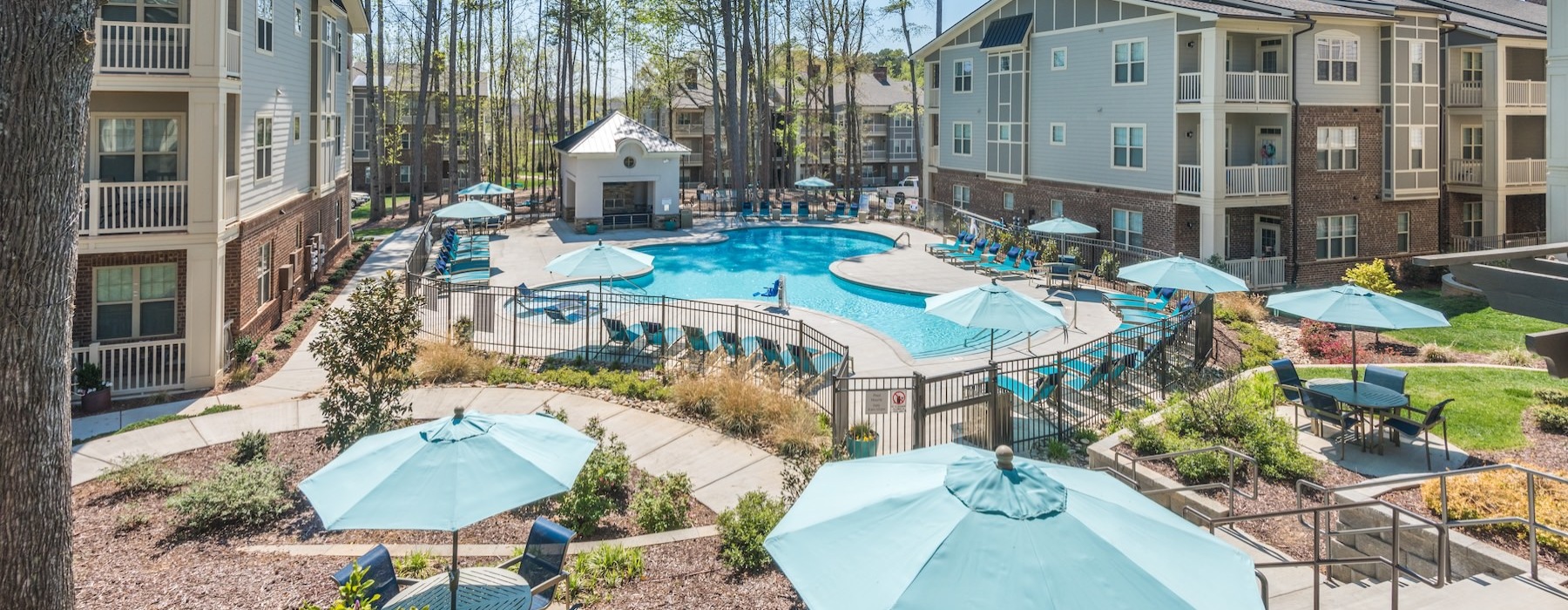 a courtyard with a pool and umbrellas