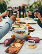 a group of people having a meal around an outdoor table